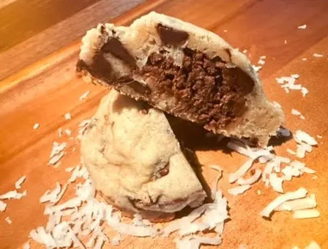 Coco Lava Chip cookie cut open revealing a molten chocolate coconut center